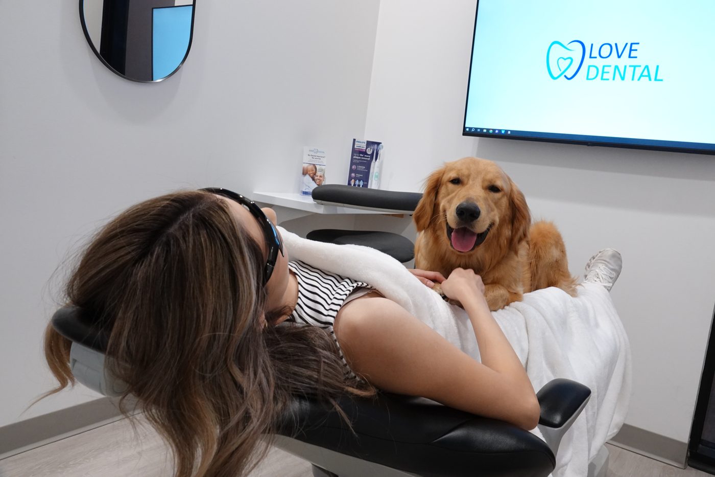 A Love Dental patient with Grizzly, our therapy dog, by her side